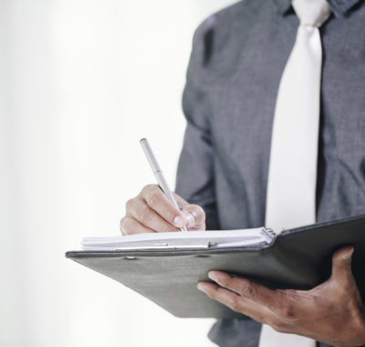 Close-up image of businessman signing contracts in folder